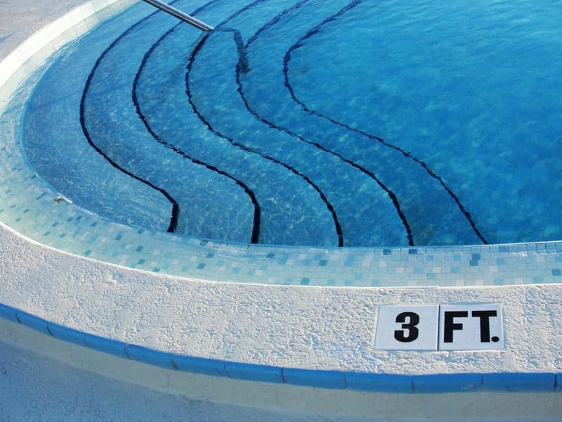Custom-designed inground pool with patio surround by Paragon Pool & Spa