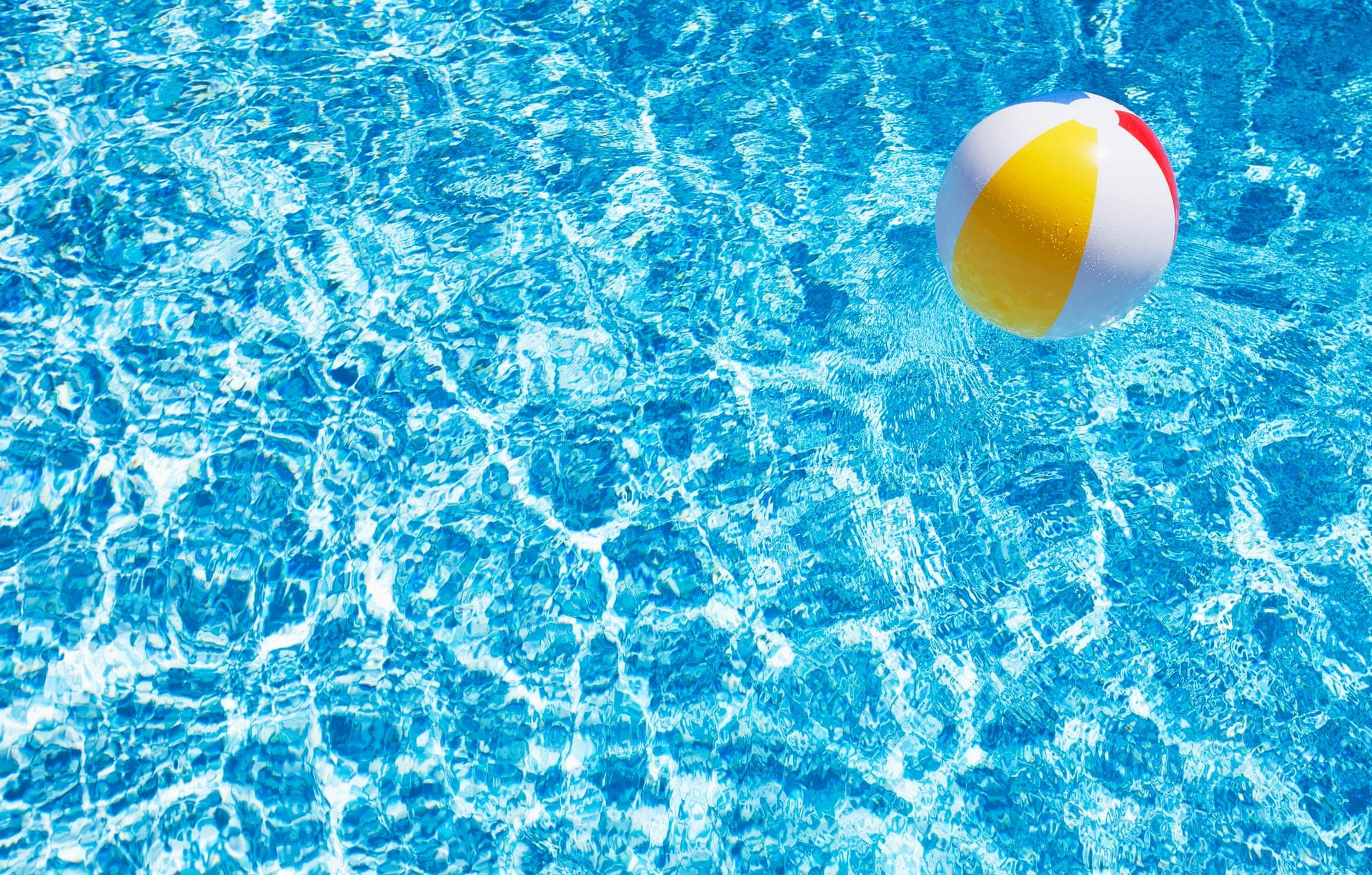Family-friendly pool with beach ball on a sunny Minnesota day